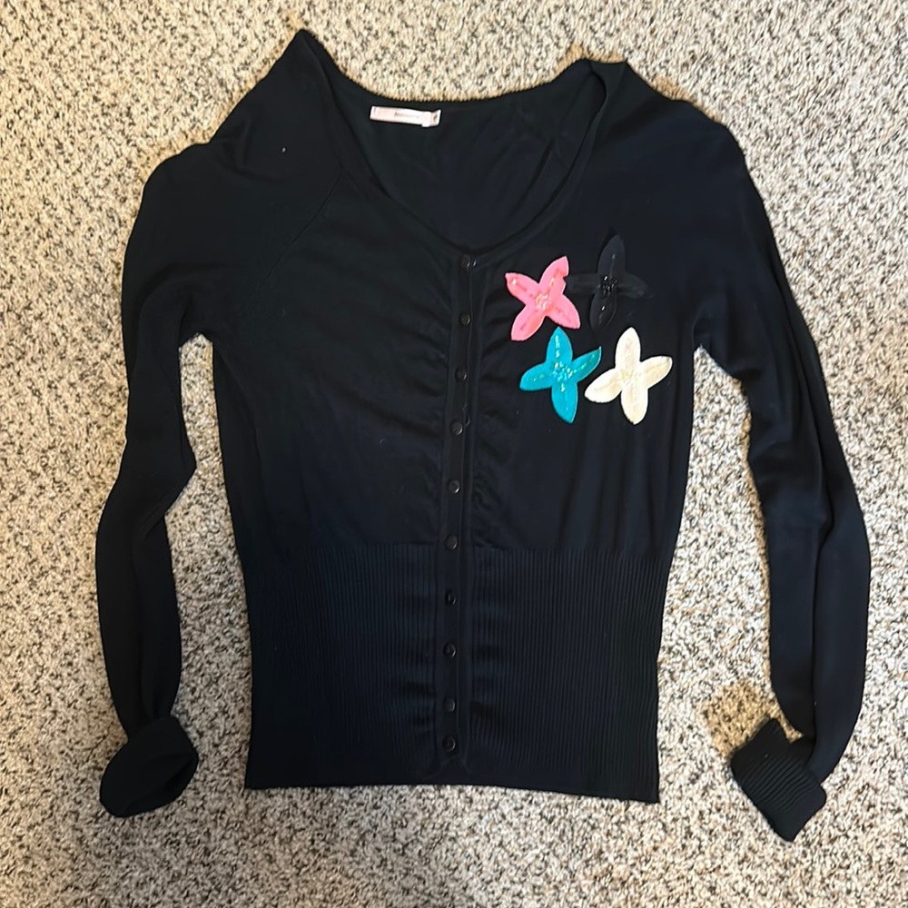 Black sweater like top with colorful flower details.